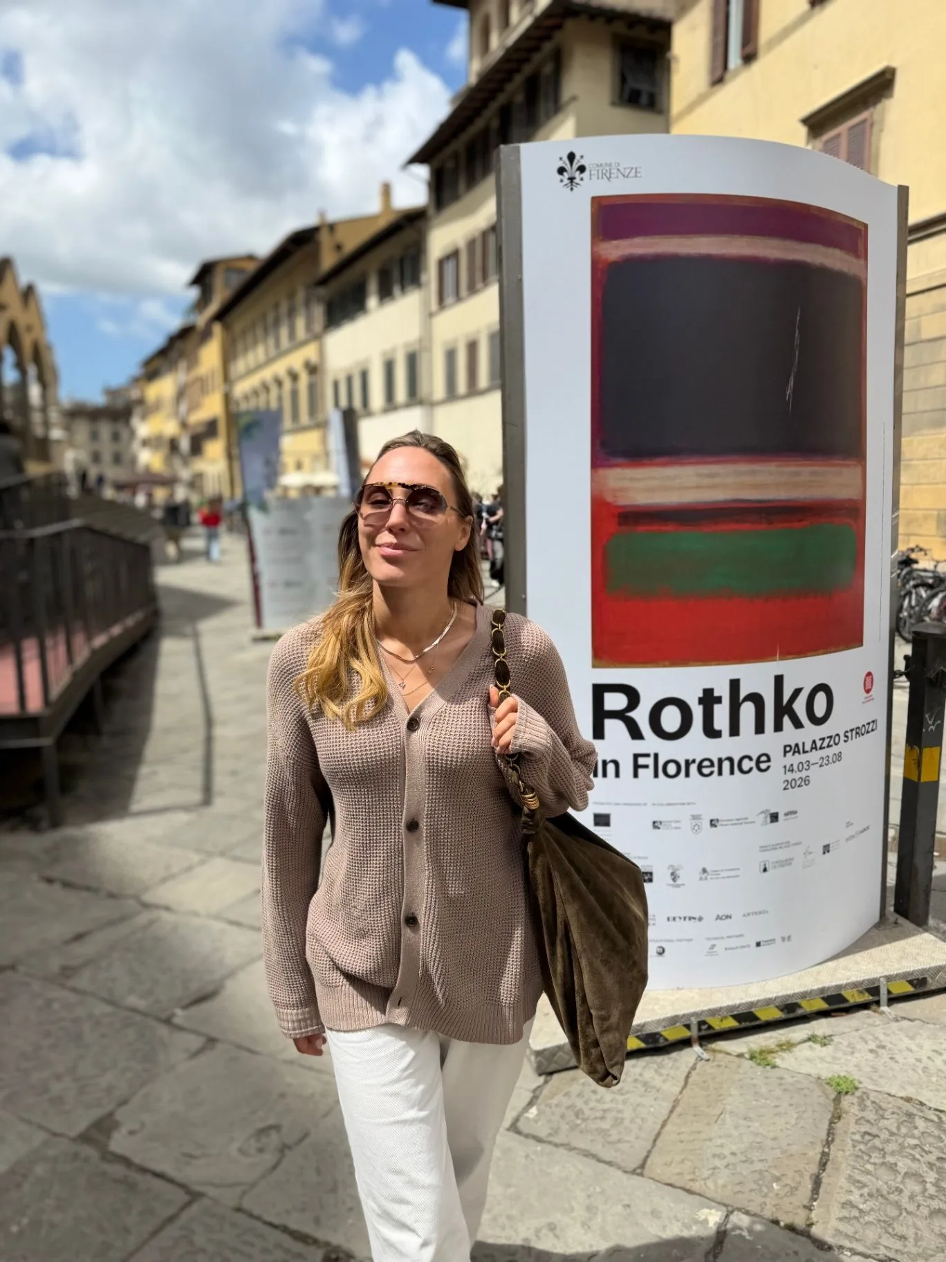 Magdalena Lemanska standing in Florence beside a Rothko exhibition poster